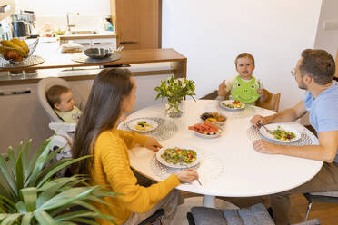 Smiling boy having breakfast with father at home - NDEF00739