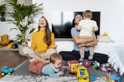 Happy family spending leisure time in living room at home - NDEF00751