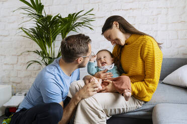 Glückliche Eltern spielen mit Baby Junge im Wohnzimmer zu Hause - NDEF00758
