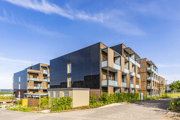 Deutschland, Baden-Württemberg, Stuttgart, Solarmodule an der Seite eines modernen Mehrfamilienhauses in einem Vorort - WDF07308