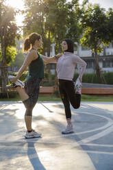 Frauen, die sich im Sportplatz die Beine vertreten - IKF00869