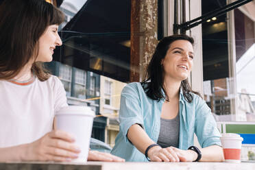 Lächelnde Freunde mit Kaffee im Straßencafé - AMWF01437