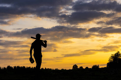 Silhouette eines Mannes mit Baseballschläger in der Abenddämmerung - STSF03737