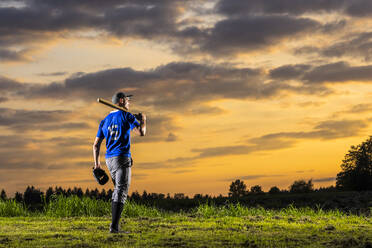 Sportlicher Mann mit Baseballschläger in der Abenddämmerung - STSF03738