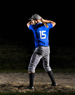 Junger Mann hält Baseballschläger bei Nacht - STSF03745