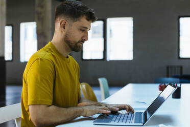 Businessman working on laptop at desk - EBSF03546