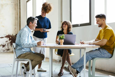 Happy business colleagues discussing and working together in office - EBSF03583