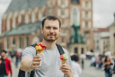 Lächelnder Tourist mit Eis in der Hand im Urlaub - VSNF01090