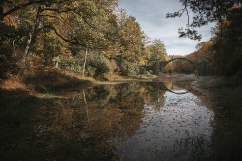 Germany, Saxony, Lake in autumn with Rakotzbrucke bridge in background - NGF00799