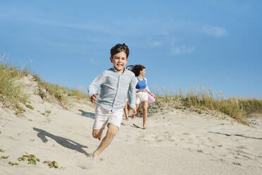 Familie läuft und genießt am Strand an einem sonnigen Tag - ASGF03850