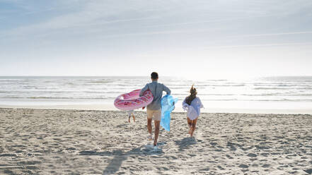 Mann und Frau genießen mit Sohn am Strand an einem sonnigen Tag - ASGF03855