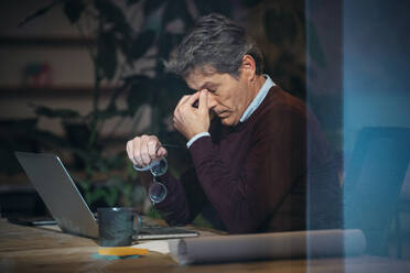 Architekt macht Pause nach der Benutzung eines Laptops im Büro - JSRF02526