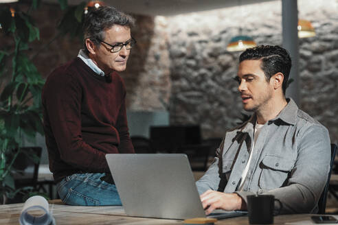 Der Sohn eines Architekten zeigt dem Vater im Büro den Laptop - JSRF02535