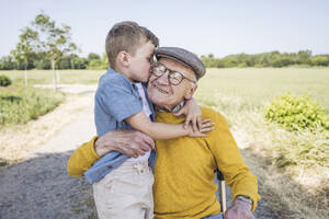 Enkel küsst Großvater auf die Wangen auf dem Feld - UUF28981