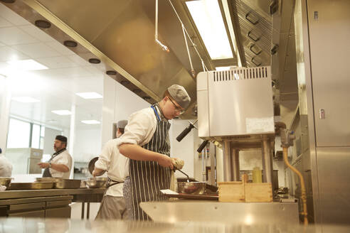 Young cooks and teacher working in kitchen - ISF26073