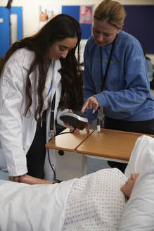 Medical student learning how to measure blood pressure - ISF26094
