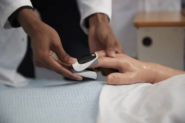 Medical student using pulse oximeter on dummy - ISF26100