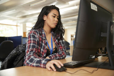 Female student using computer in library - ISF26108