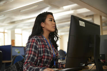 Female student using computer in library - ISF26114