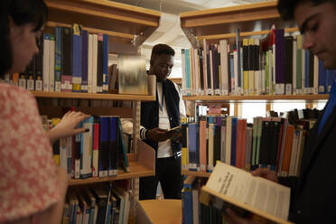 University students reading books in library - ISF26124