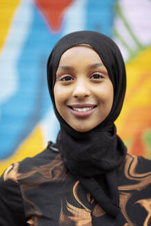 Portrait of smiling young woman wearing hijab - ISF26139