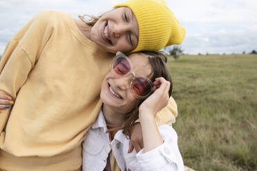 Smiling girl friends (10-11) wearing fashionable accessories - ISF26178