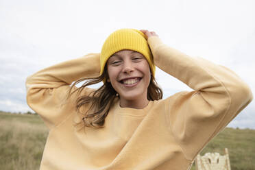 Portrait of smiling girl (10-11) wearing yellow beanie - ISF26182