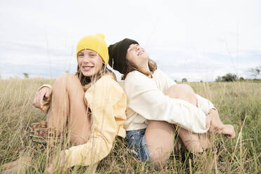 Smiling girl friends (10-11) sitting in grass - ISF26188