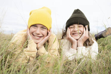 Portrait of smiling girl friends (10-11) lying in grass - ISF26192