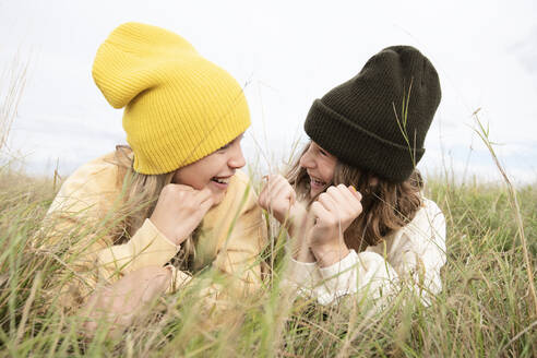 Smiling girl friends (10-11) lying in grass - ISF26194