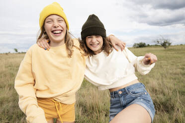 Smiling girl friends (10-11) frolicking in field - ISF26205