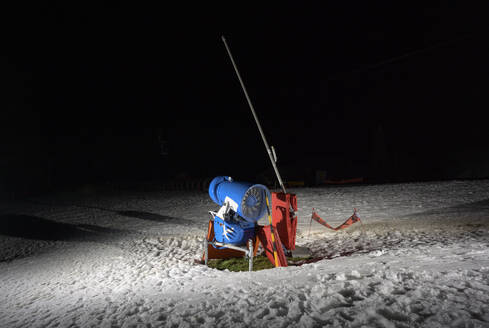 Snow cannon on ski slope at night - ISF26250