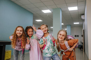 Smiling schoolgirls standing in school corridor - MDOF01398