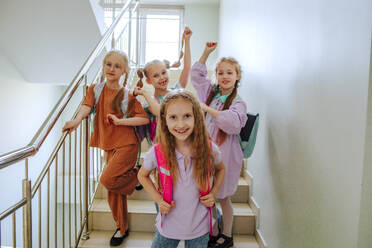 Cheerful schoolgirls standing on school staircase - MDOF01401