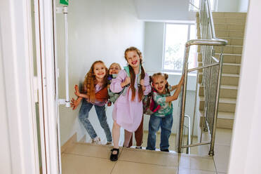 Cheerful schoolgirls standing on stairs at break time - MDOF01405