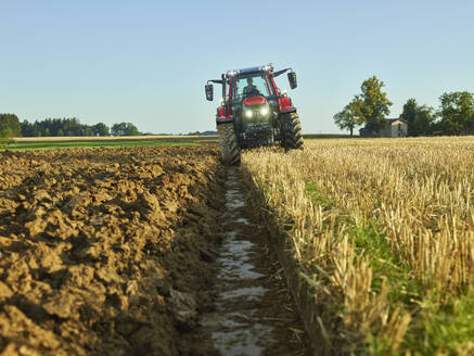 Landwirt fährt Traktor inmitten von Nutzpflanzen auf einem Bauernhof - CVF02450