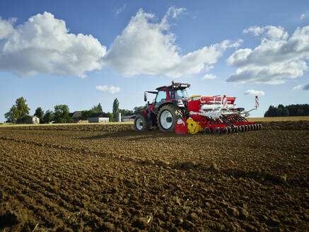 Landwirt mit Traktor auf einem Feld unter freiem Himmel - CVF02451