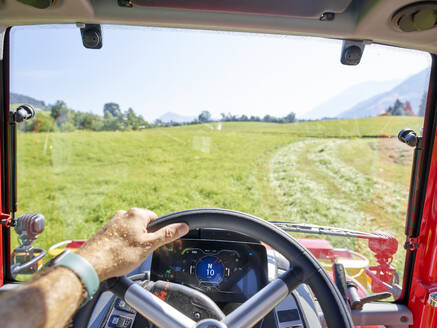 Hand eines Landwirts, der das Lenkrad eines Traktors auf einem Bauernhof hält - CVF02452