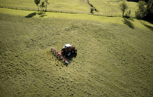 Mann mäht Land mit Traktor an einem sonnigen Tag - CVF02454