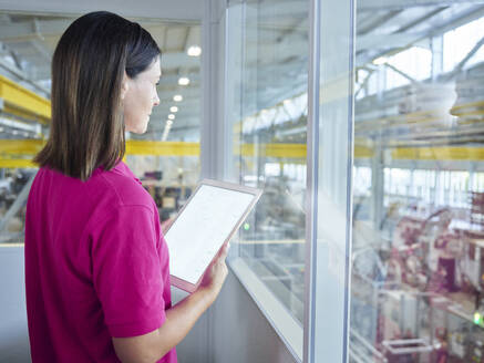 Engineer holding tablet PC in factory - CVF02460