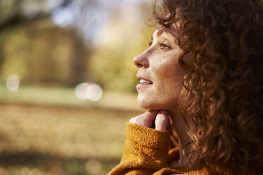 Thoughtful young redhead woman at autumn park - ABIF02061