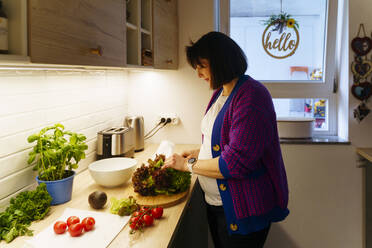 Pregnant woman with vegetables preparing food at home - NJAF00415