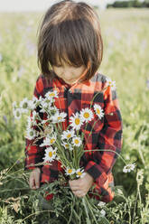 Junge hält Blumenstrauß im Feld - ANAF01557