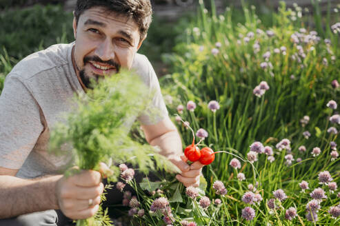 Farmer holding radish and dill in field - ANAF01562