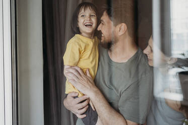 Smiling father holding son at home - ANAF01566