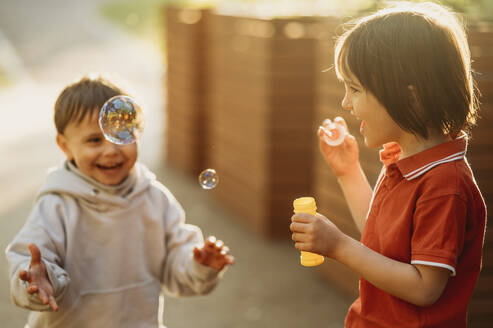 Happy brothers playing with soap bubbles - ANAF01589