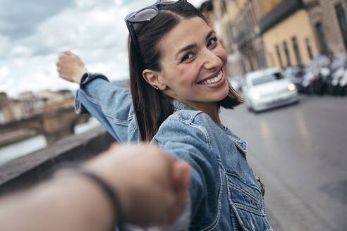 Lächelnde Frau hält die Hand ihres Partners auf der Straße - JSRF02542
