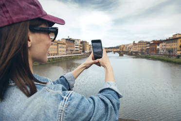 Frau fotografiert den Fluss Arno mit ihrem Smartphone - JSRF02555