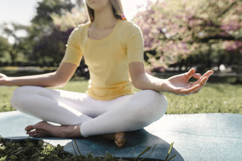 Teenage girl meditating at park - AAZF00728