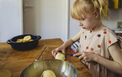 Mädchen schneidet Äpfel in der Küche zu Hause - IHF01397